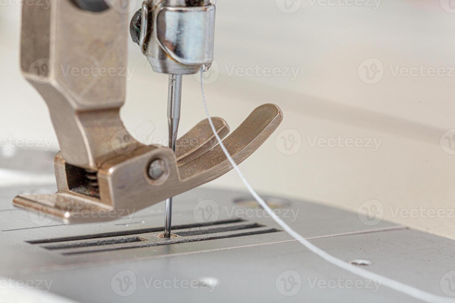 Sewing machine needle with thread and fabric photo