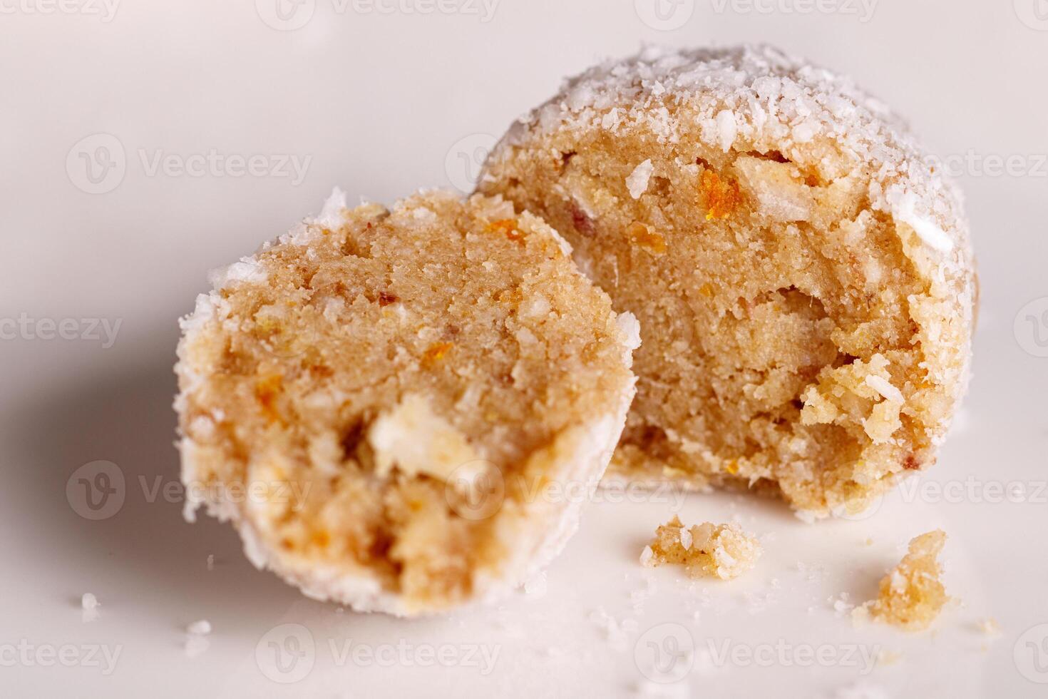 Beautiful sweets with coconut on a white plate on a black background photo