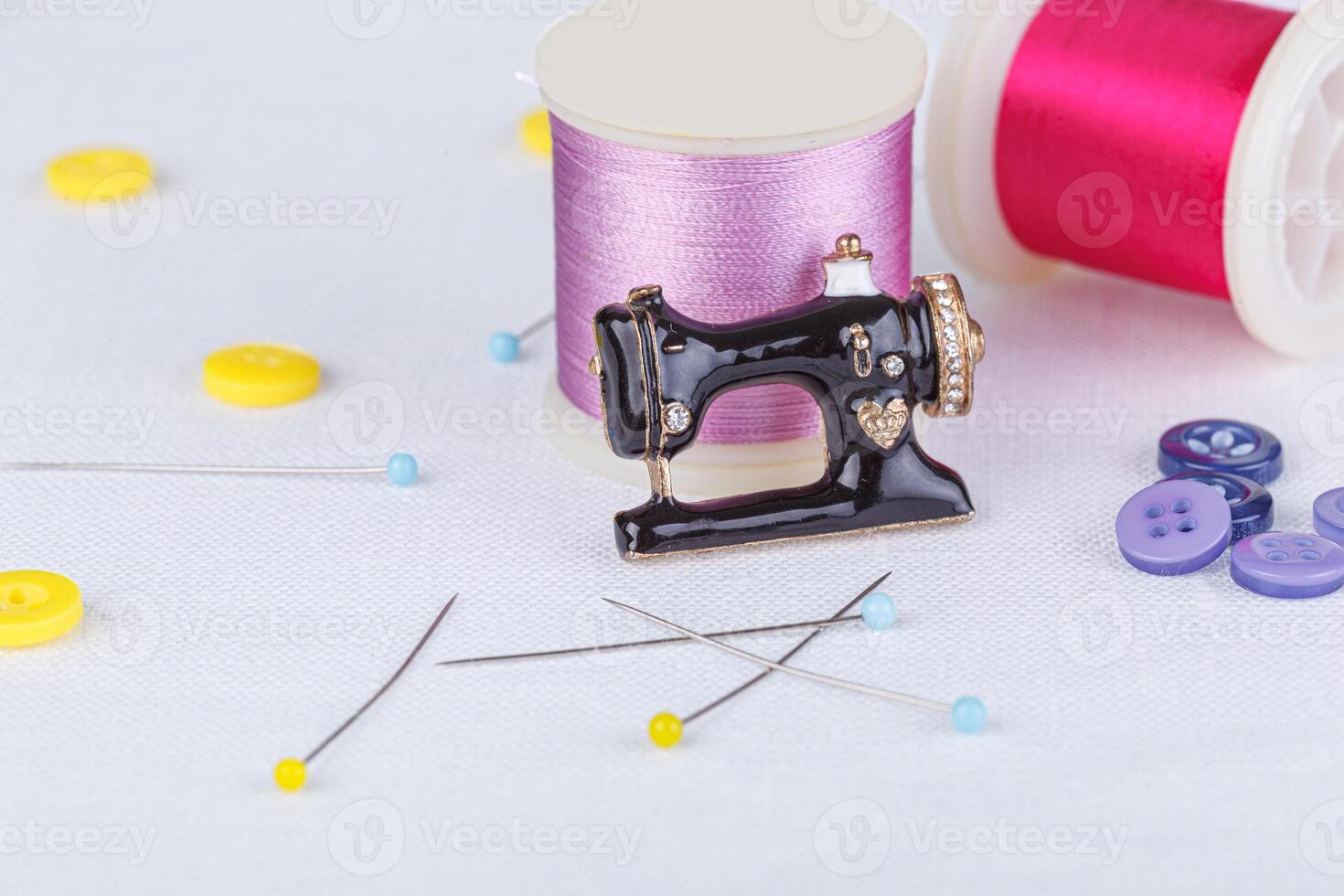still life of a skein of thread for sewing, needles, buttons, sewing machine on a white background photo