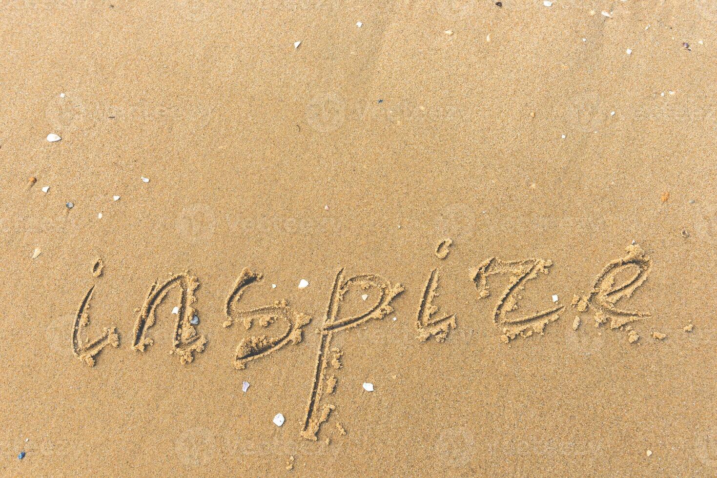 Inspire written on the beach sand photo