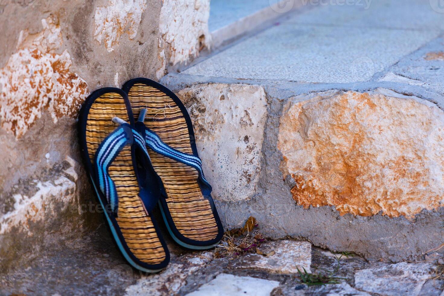 Beach flip-flops on the old wall background photo