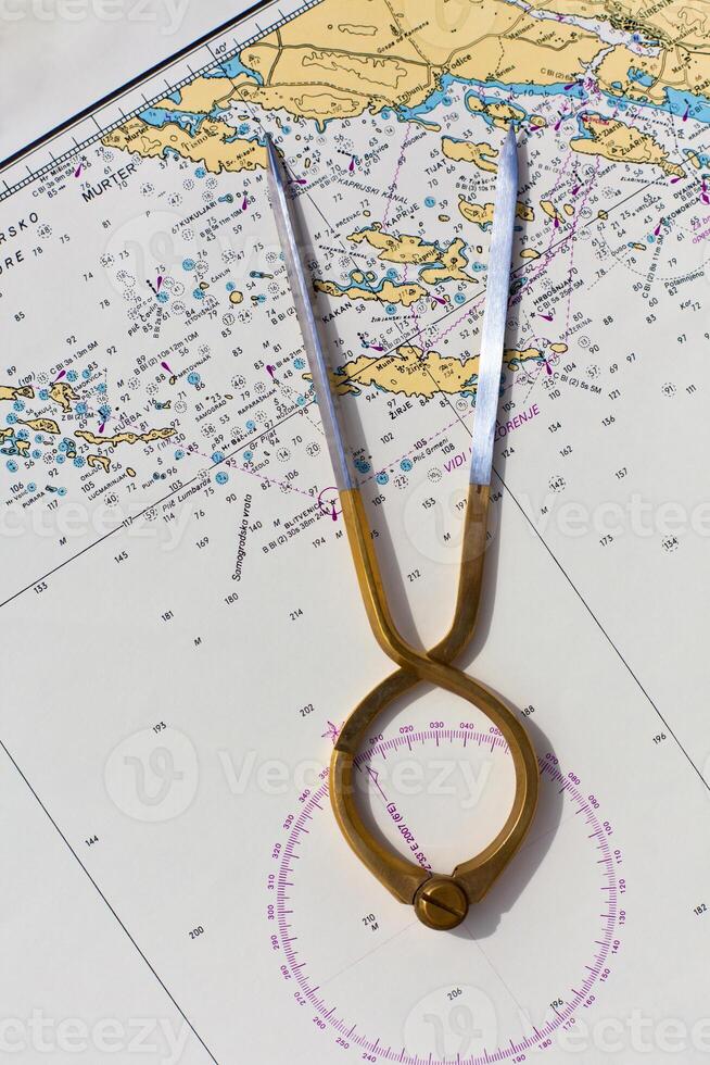Pair of compasses for navigation on a sea map photo