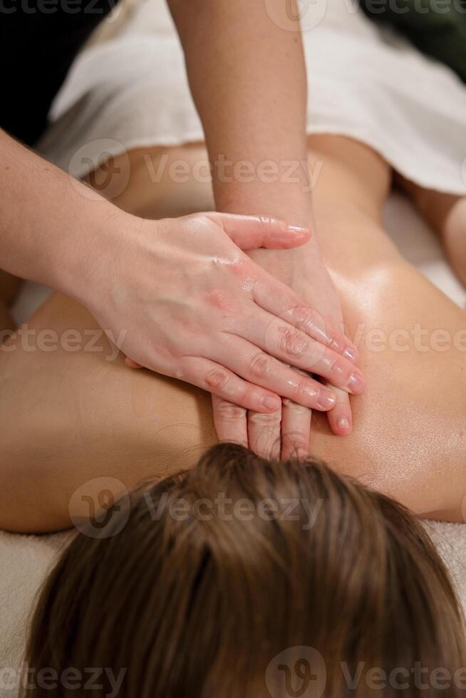 Therapist performing back massage with hands on a relaxed patient. Wellness and relaxation concept photo