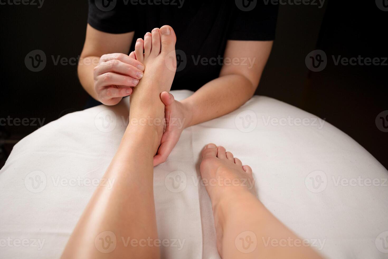 Close up of a therapist hands massaging a client foot. Foot reflexology and relaxation concept photo
