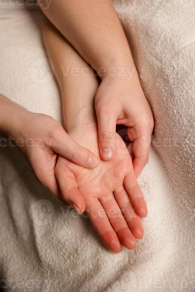 Therapist massaging a client palm during a spa session. Stress relief and wellness therapy concept photo