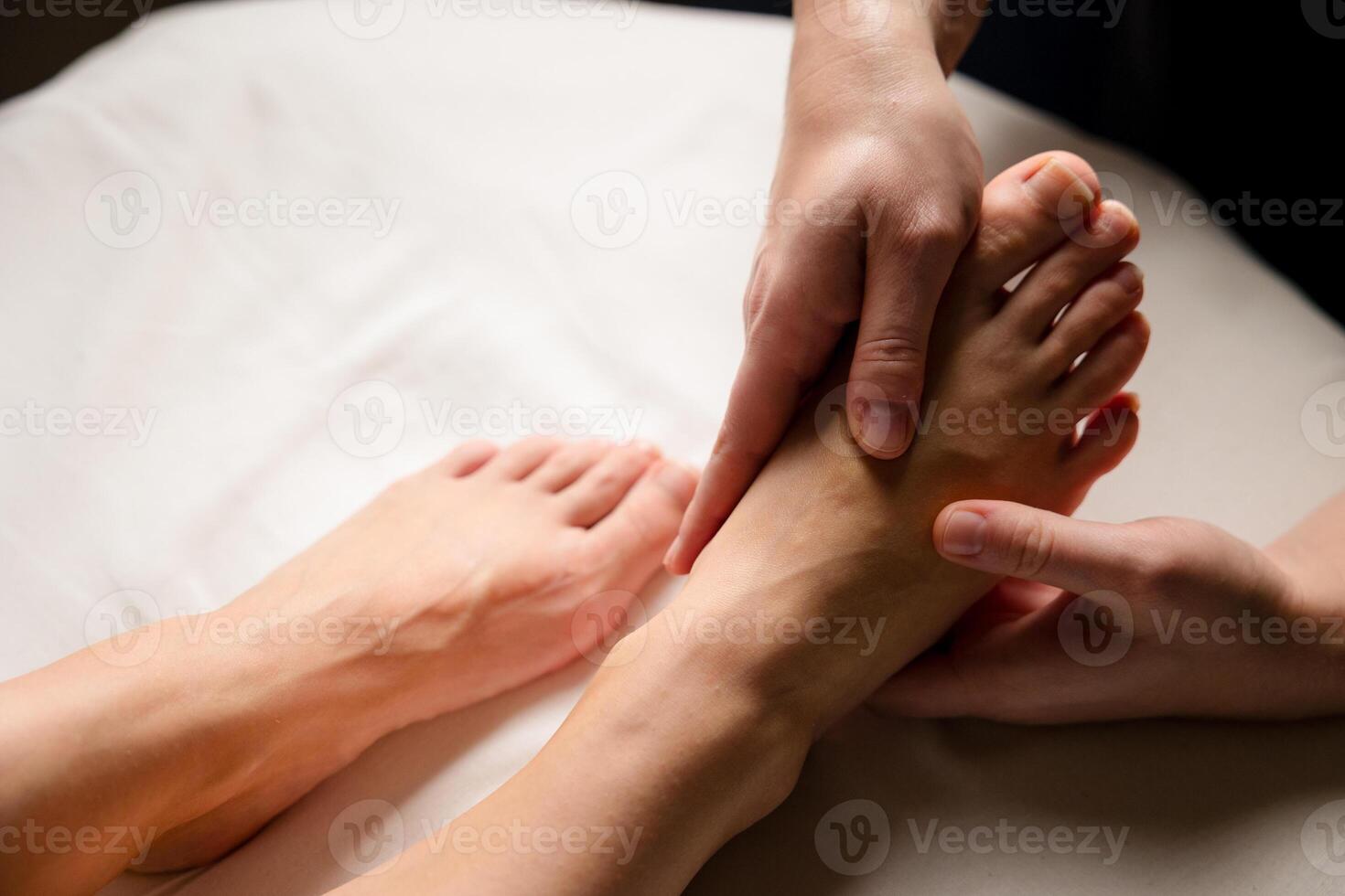 Close up of a therapist hands massaging a client foot. Foot reflexology and relaxation concept photo