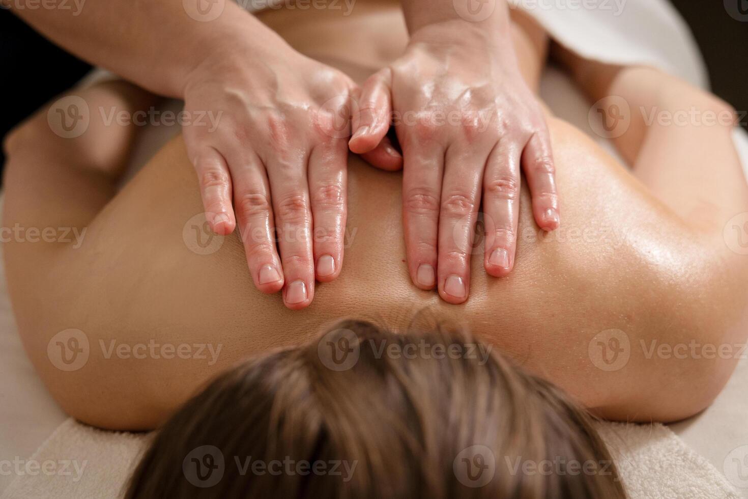 Therapist massaging the shoulder muscles with both hands during a therapy session. Stress relief and wellness concept photo