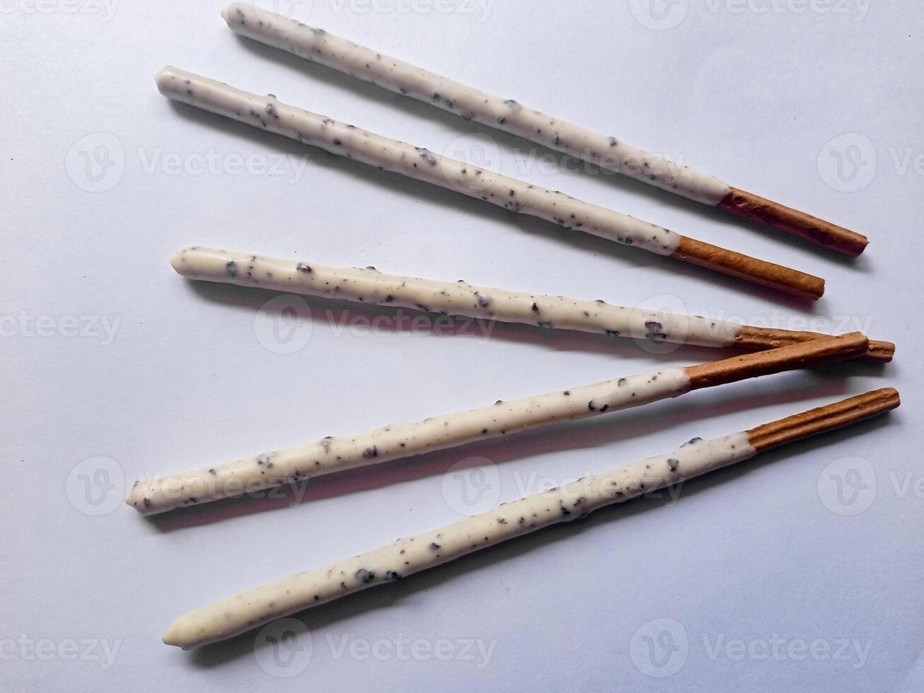 Chocolate biscuit stick coated with milk flavour confectionery and crushed cookies and cream taste isolated on white background. photo