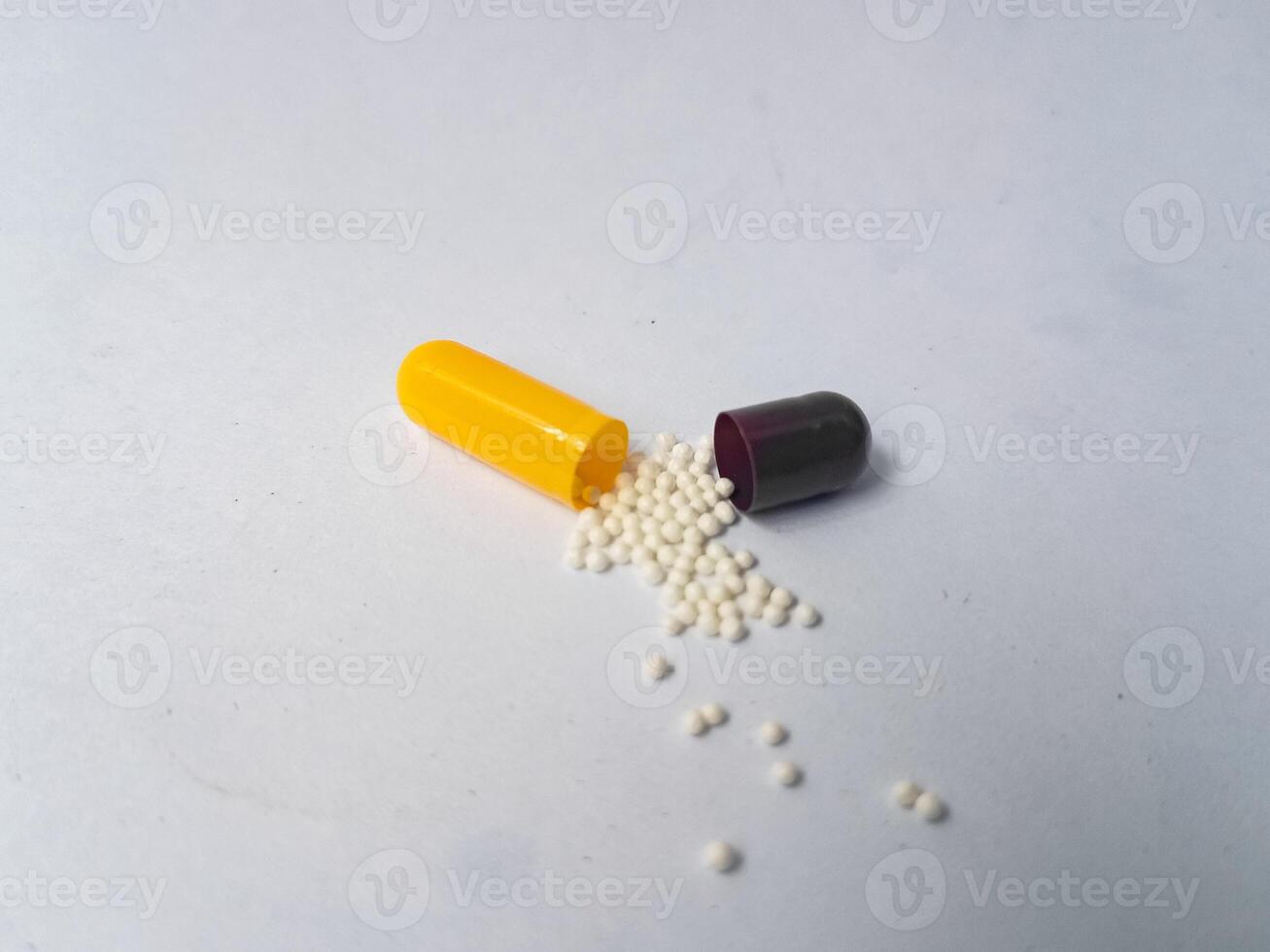 Capsules and granules of omeprazole isolated on white background photo