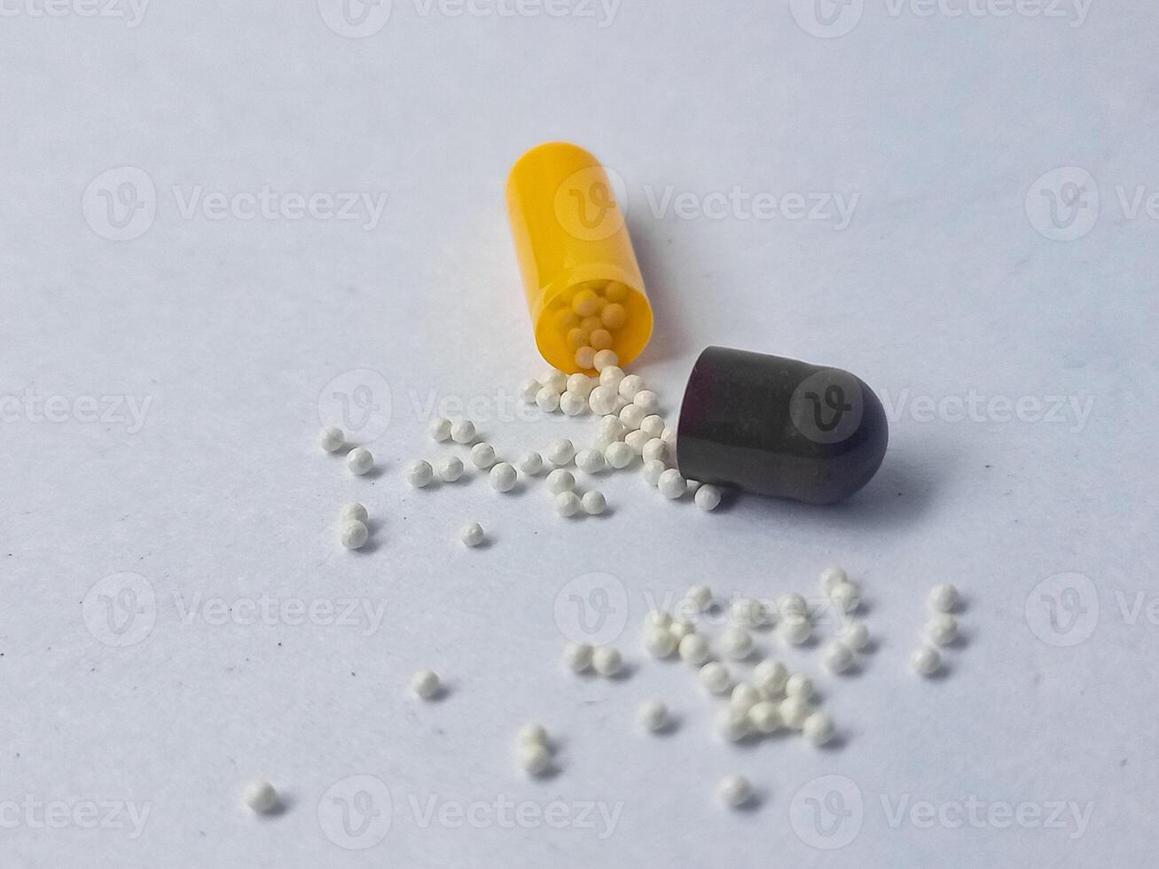 Capsules and granules of omeprazole isolated on white background photo