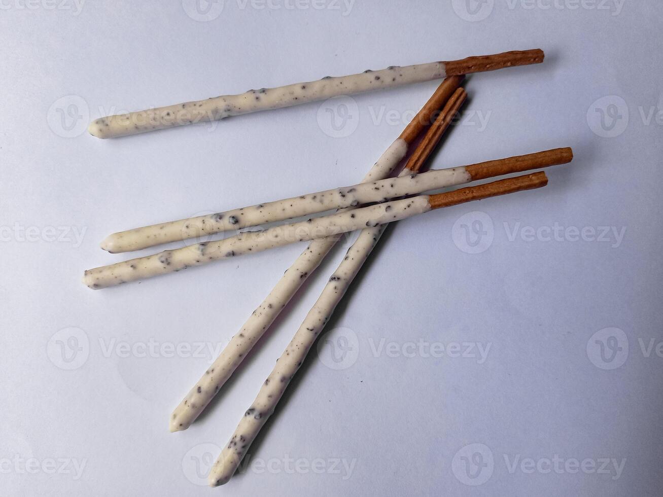 Chocolate biscuit stick coated with milk flavour confectionery and crushed cookies and cream taste isolated on white background. photo