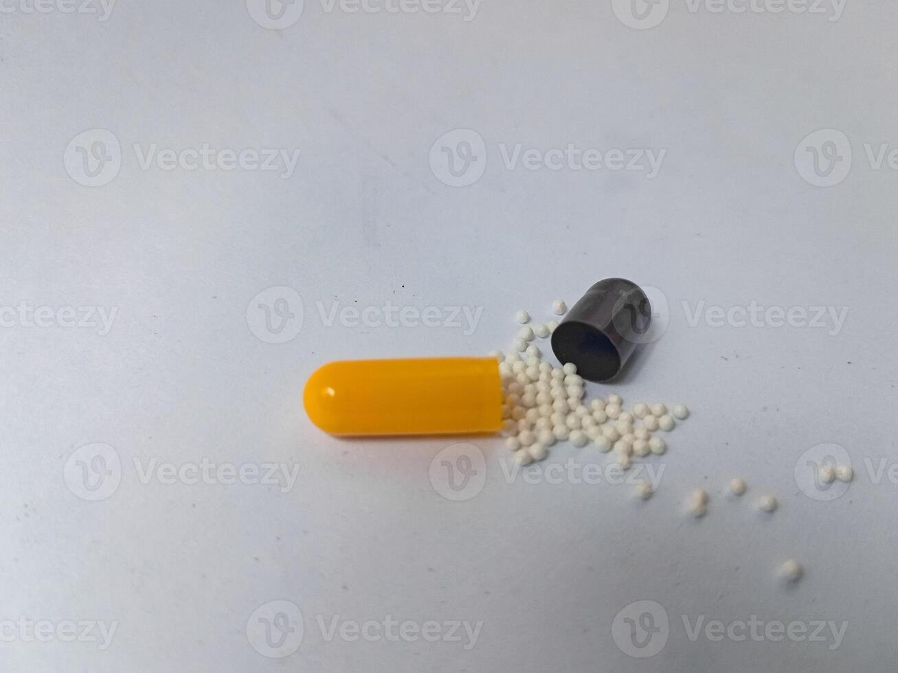 Capsules and granules of omeprazole isolated on white background photo