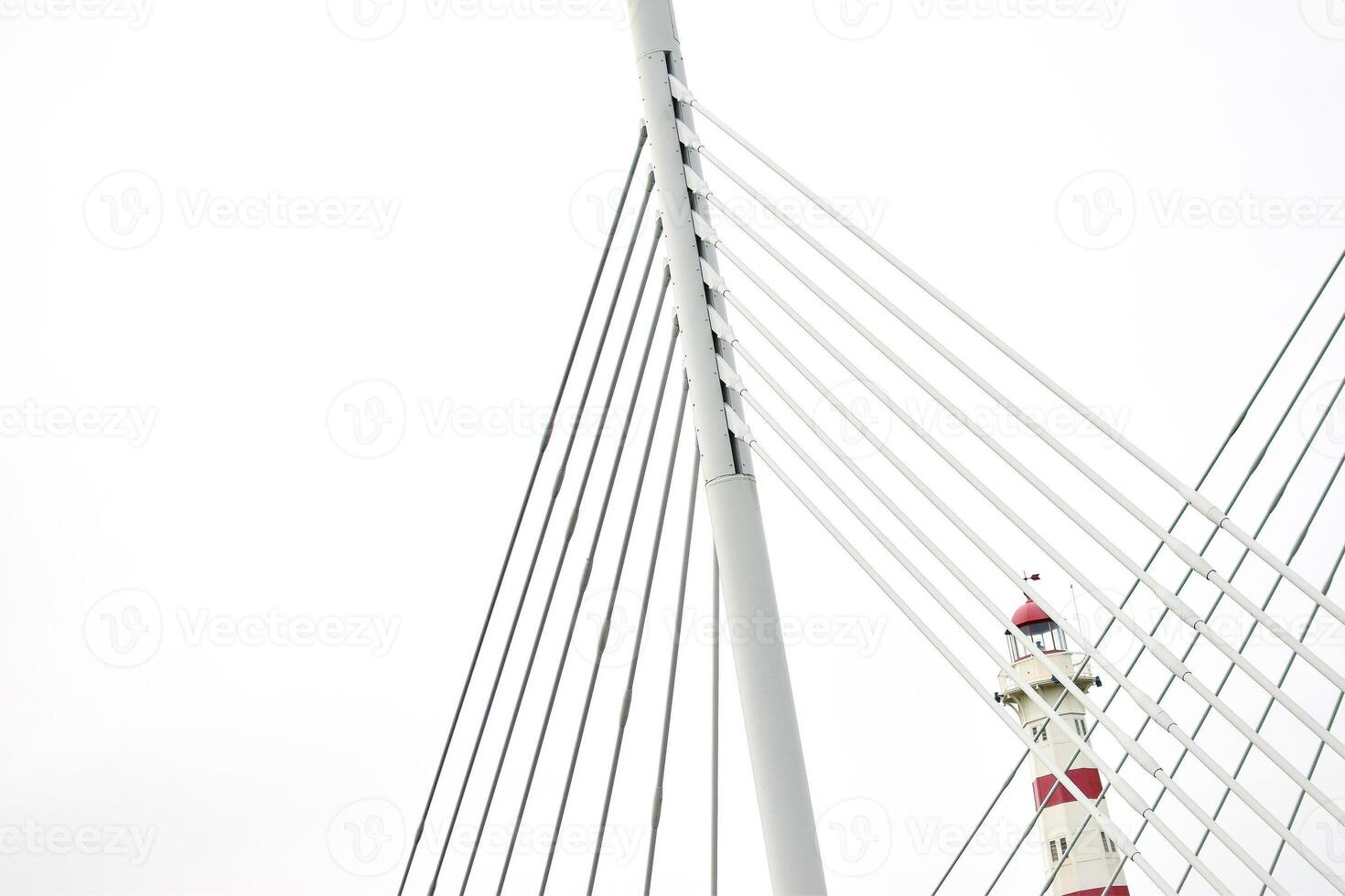 View of a red and white light house and white metal poles photo