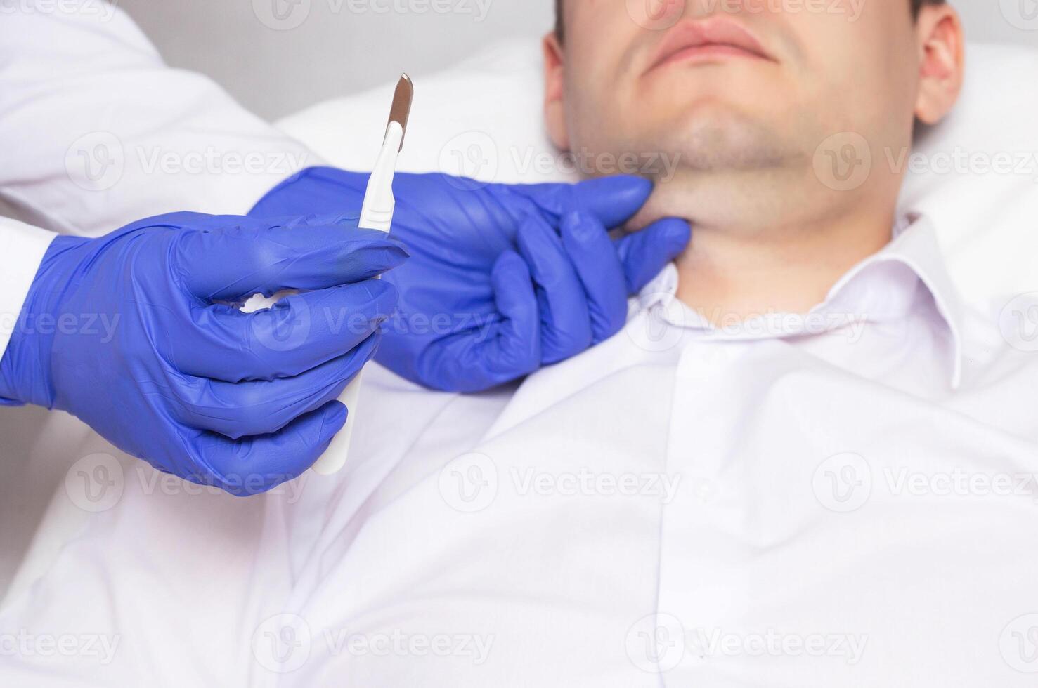 Doctor holding a surgical scalpel on the background of the face of a man with a double chin. Concept of plastic surgery in cosmetology, anaplasty photo