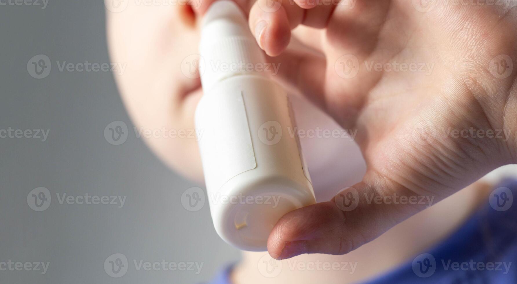 A caucasian girl puts drops into her nose and an anti-inflammatory spray for nasal congestion. Treatment of runny nose and sinusitis. Antibiotic medicinal spray, close-up photo