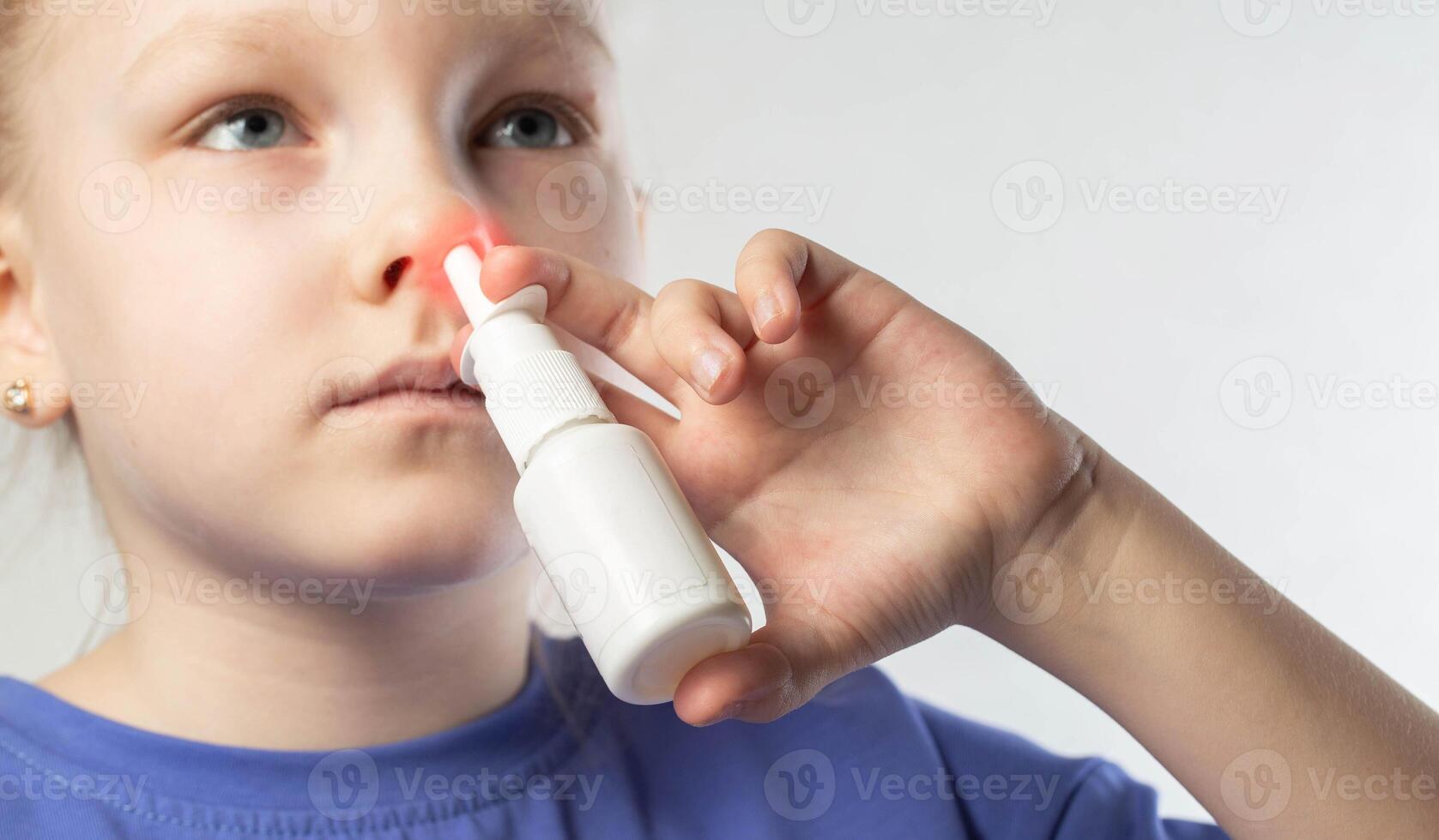 A caucasian girl puts drops into her nose and an anti-inflammatory spray for nasal congestion. Treatment of runny nose and sinusitis. Antibiotic medicinal spray, close-up photo