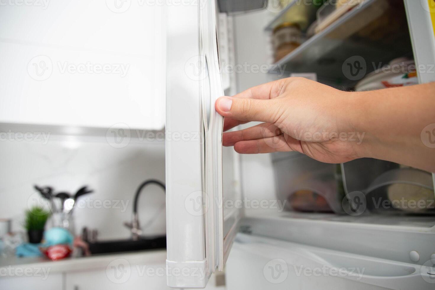 Torn and damaged sealing gum on the refrigerator door. Replacing the old sealing rubber with a new one photo