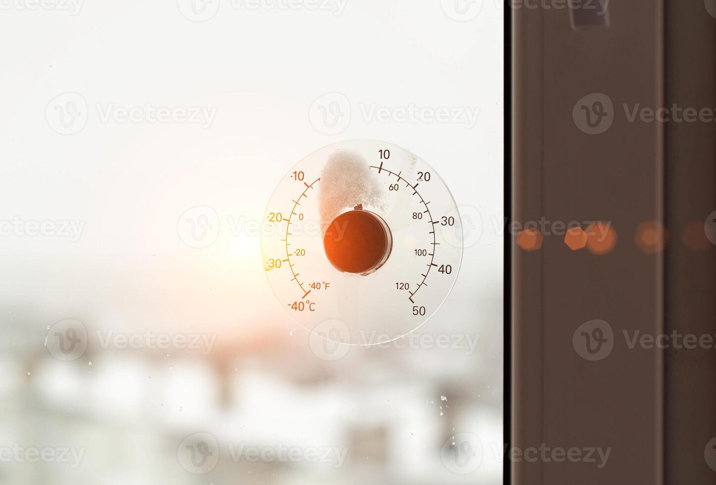 Rays of the sun against the background of a street thermometer with a snow cap. The concept of frosty weather and cooling in winter. Copy space for text, dependence photo