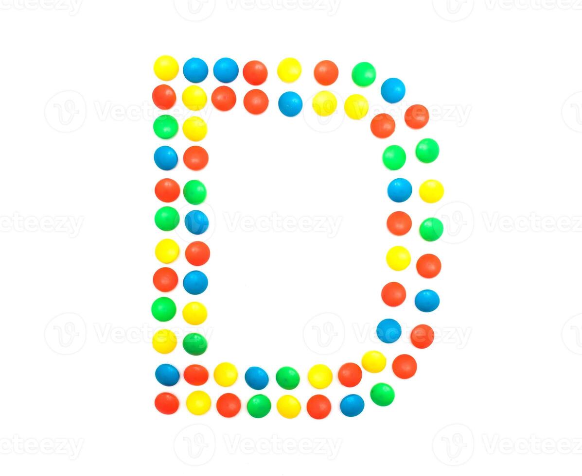 Multi-colored vitamins pills that are lined with the letter Vitamin D, close-up photo