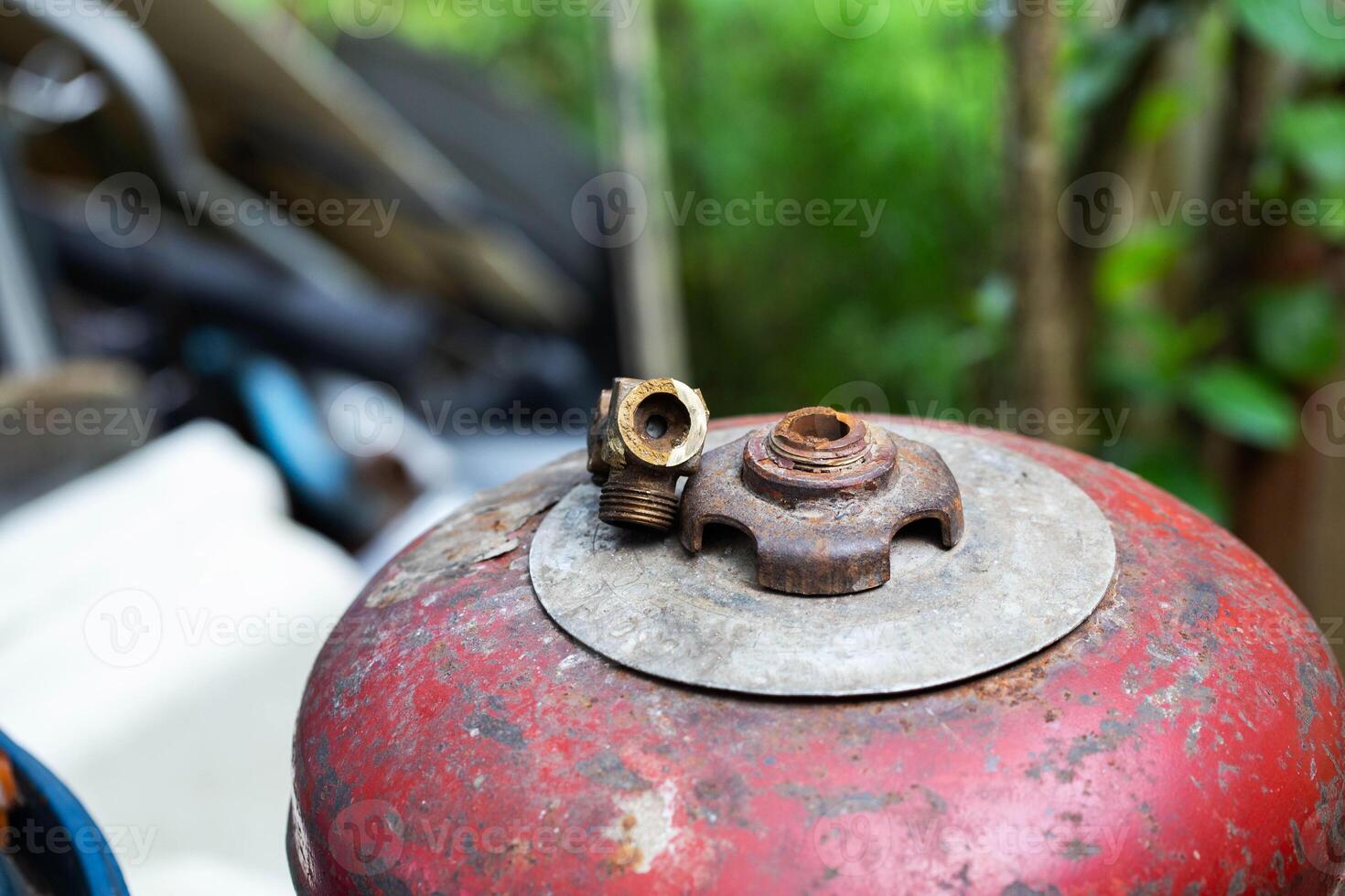 A broken gas cylinder valve lies on a red cylinder. Danger of gas leakage and explosion. Copy space for text, butane. Safety precautions photo