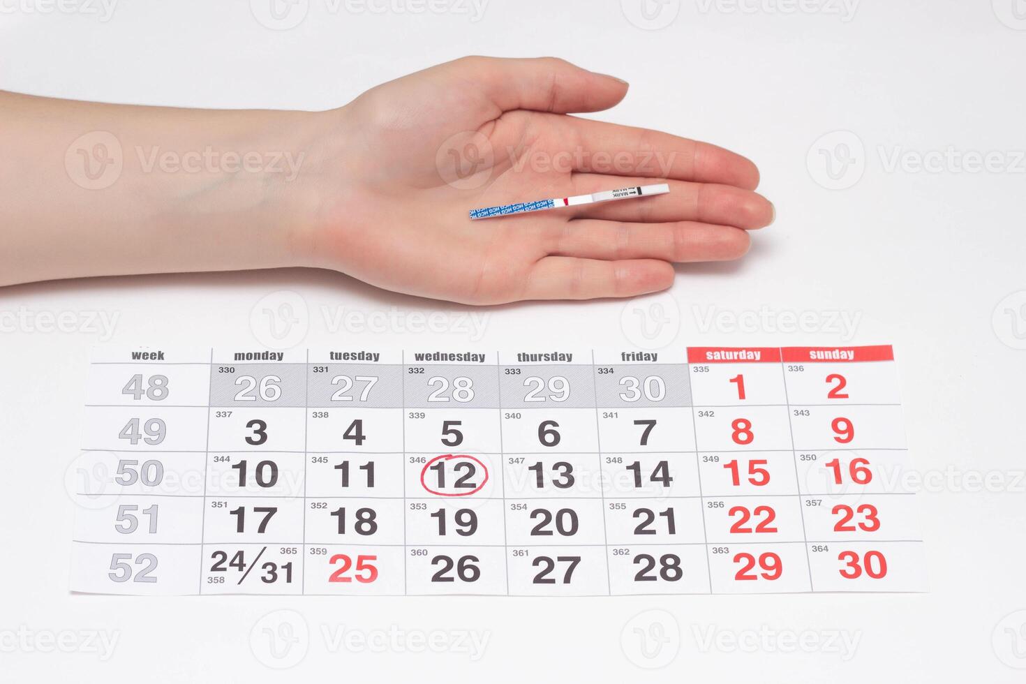 A girl holds a hand with a negative rate of pregnancy test on the background of the calendar, the day of ovulation, infertility photo