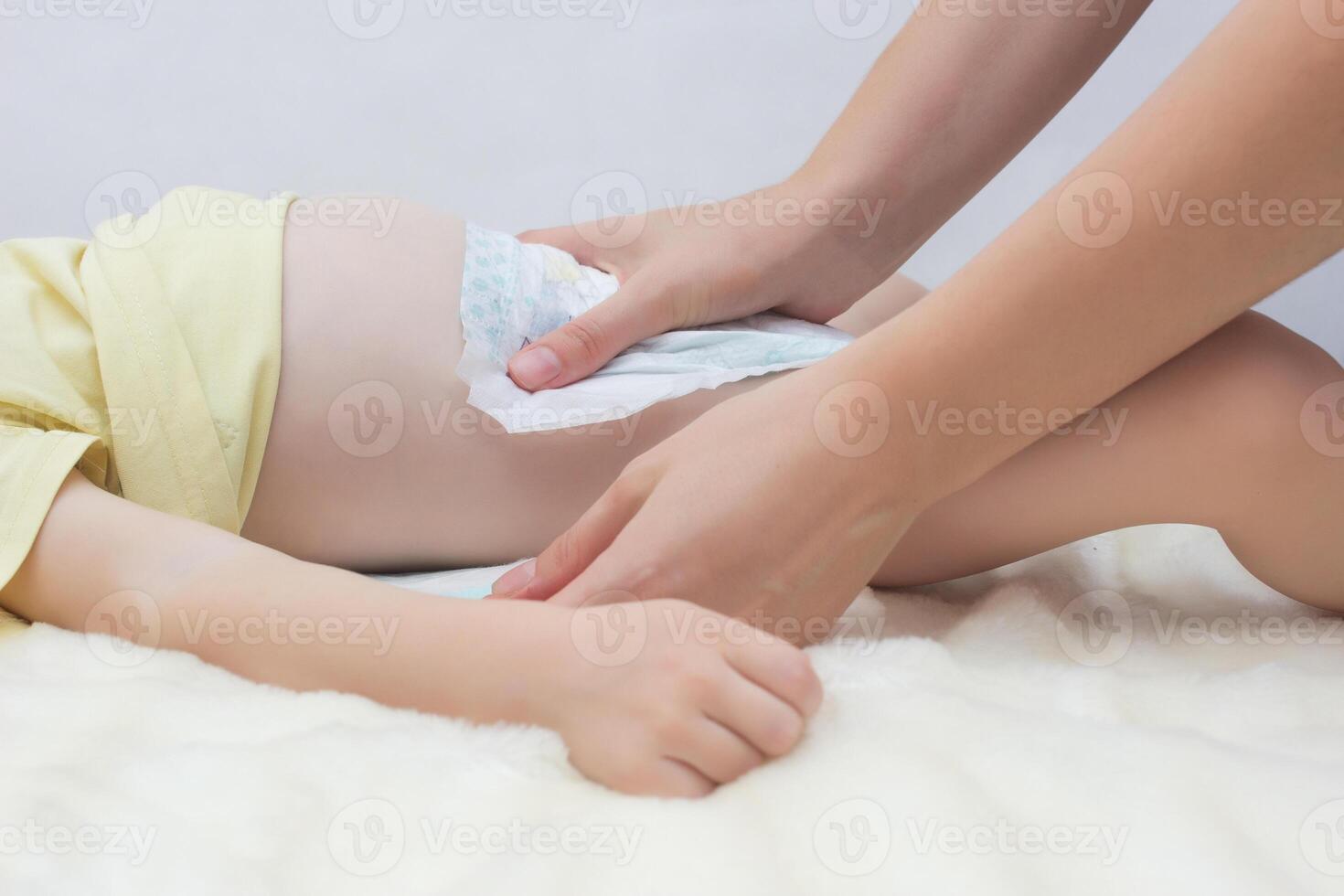 Mother changes the diaper to her little baby, close-up, nappy photo