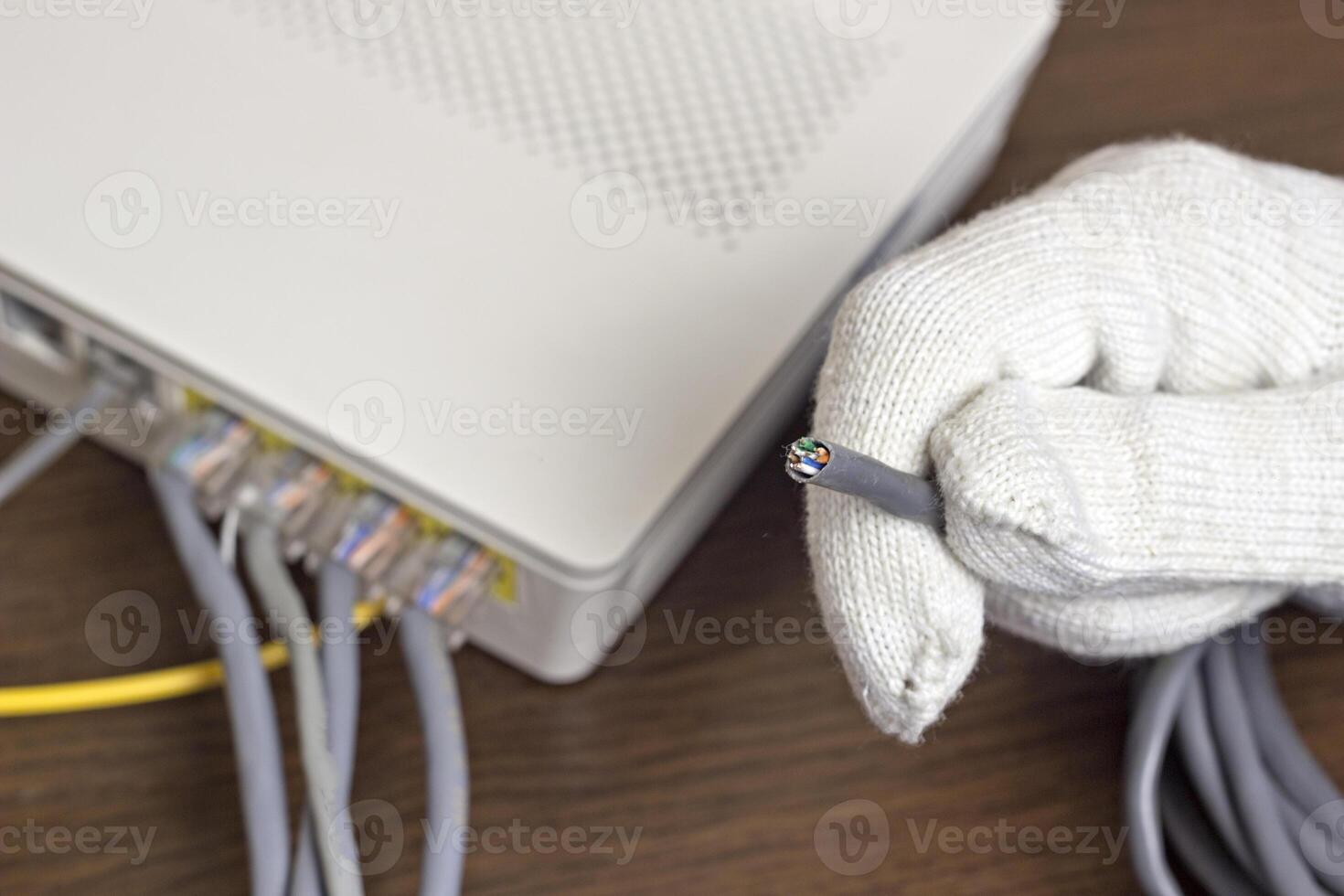 A man holds a network cable in his hand, a close-up photo