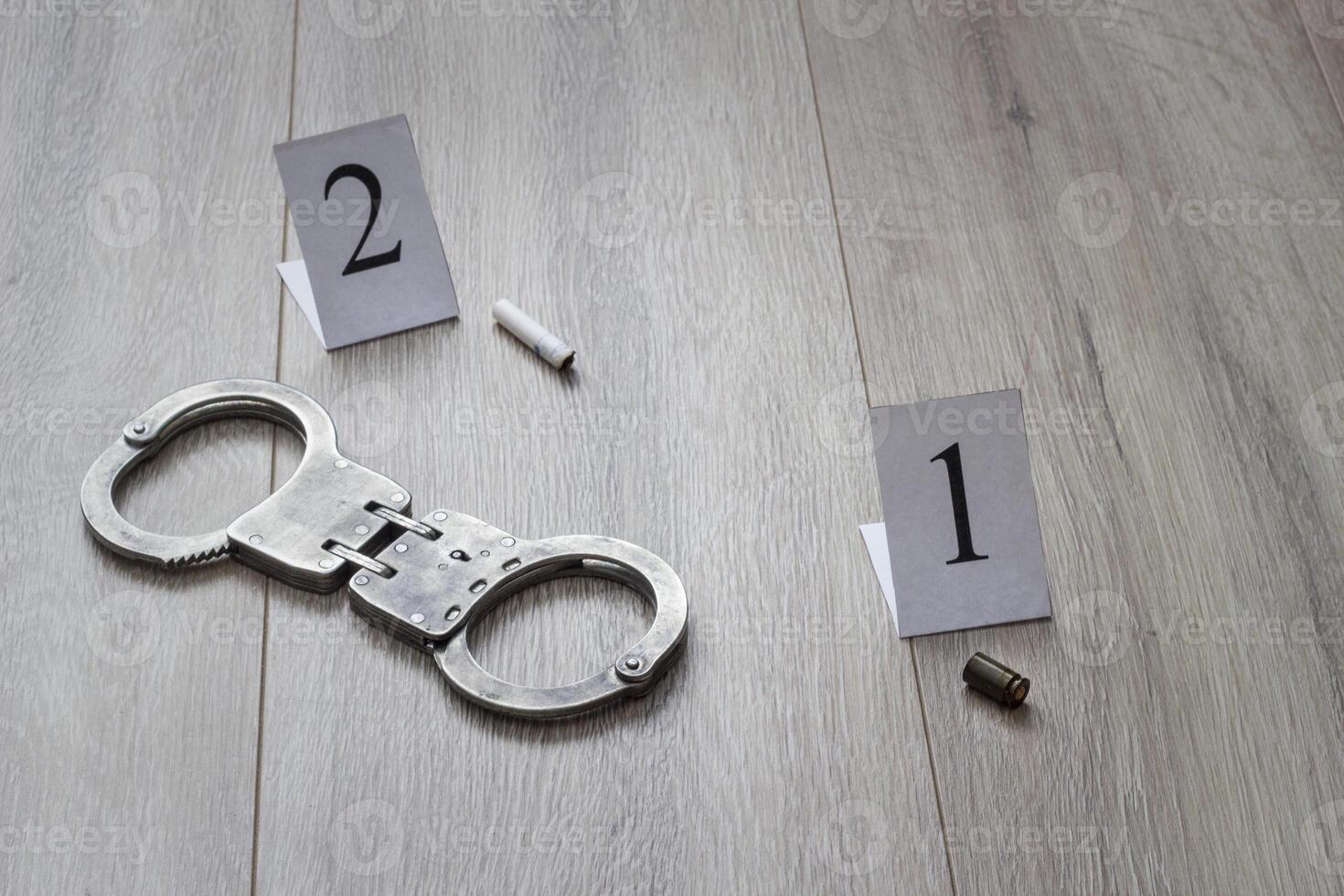 Sleeve from a gun and a cigarette butt on a wooden background, evidence and investigation, handcuffs photo