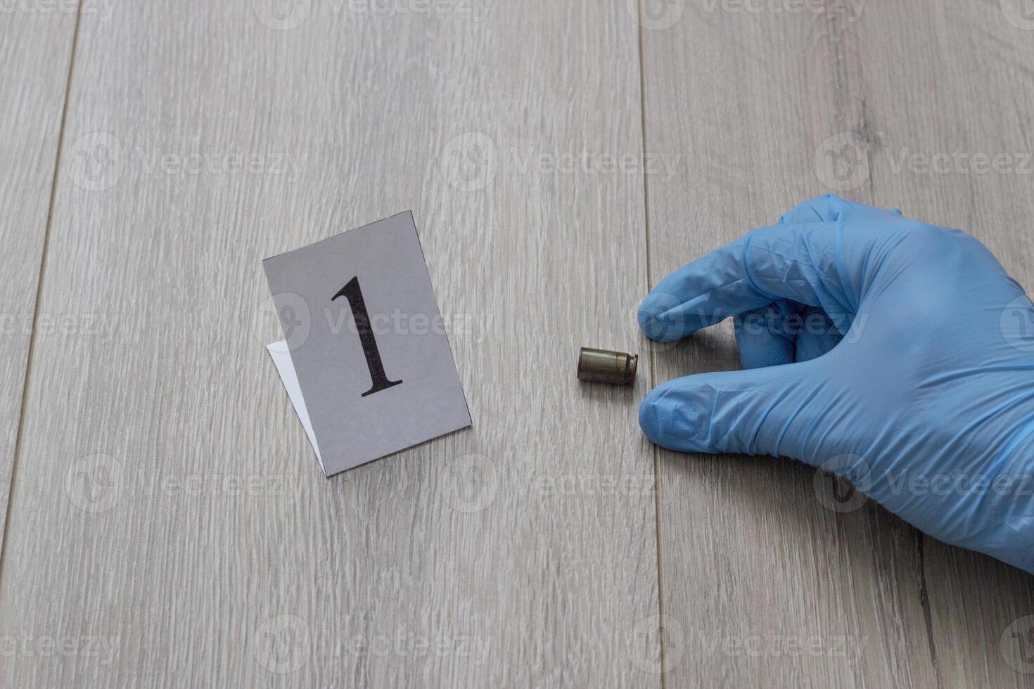 The gloved hand raises the cartridge from the cartridge, the investigation, the evidence, a close-up photo