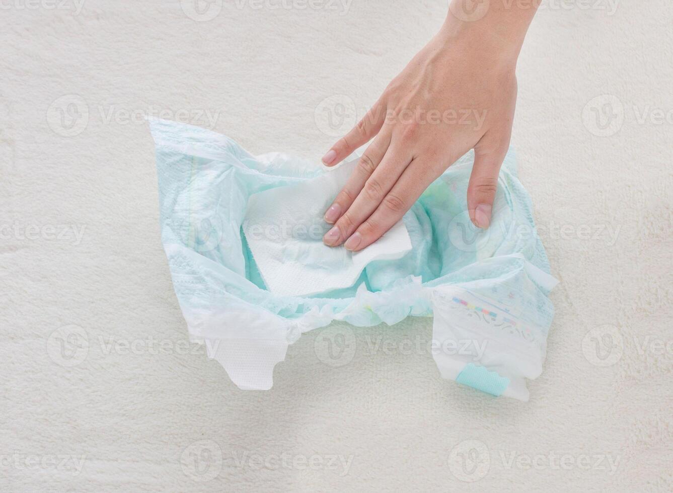The girl checks the absorbency of a baby nappy with a napkin, close-up photo