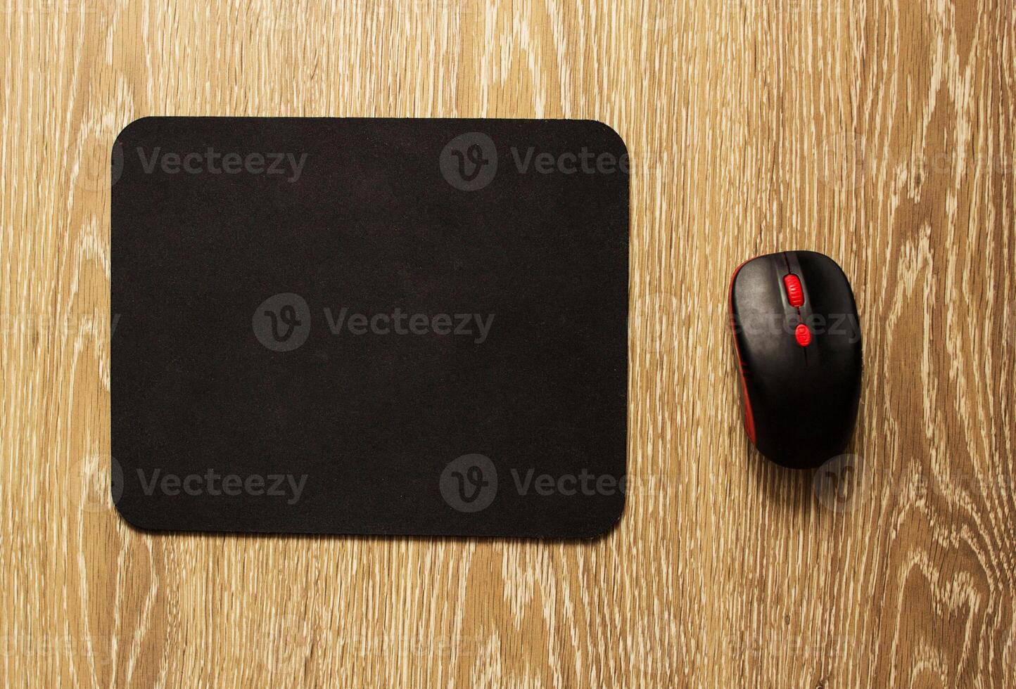 Computer mat and computer mouse on a wooden background, close-up, black computer mat photo