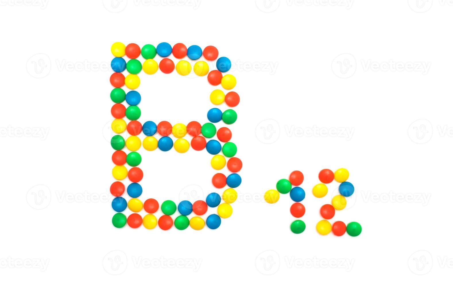 Multi-colored vitamins pills that are lined with the letter Vitamin group B12, close-up photo
