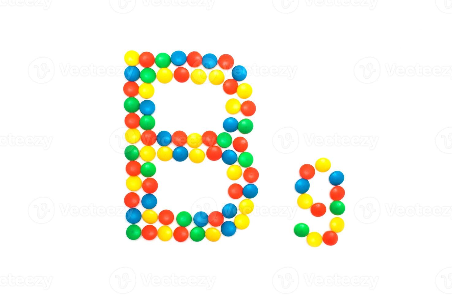 Multi-colored vitamins pills that are lined with the letter Vitamin group B9, close-up photo
