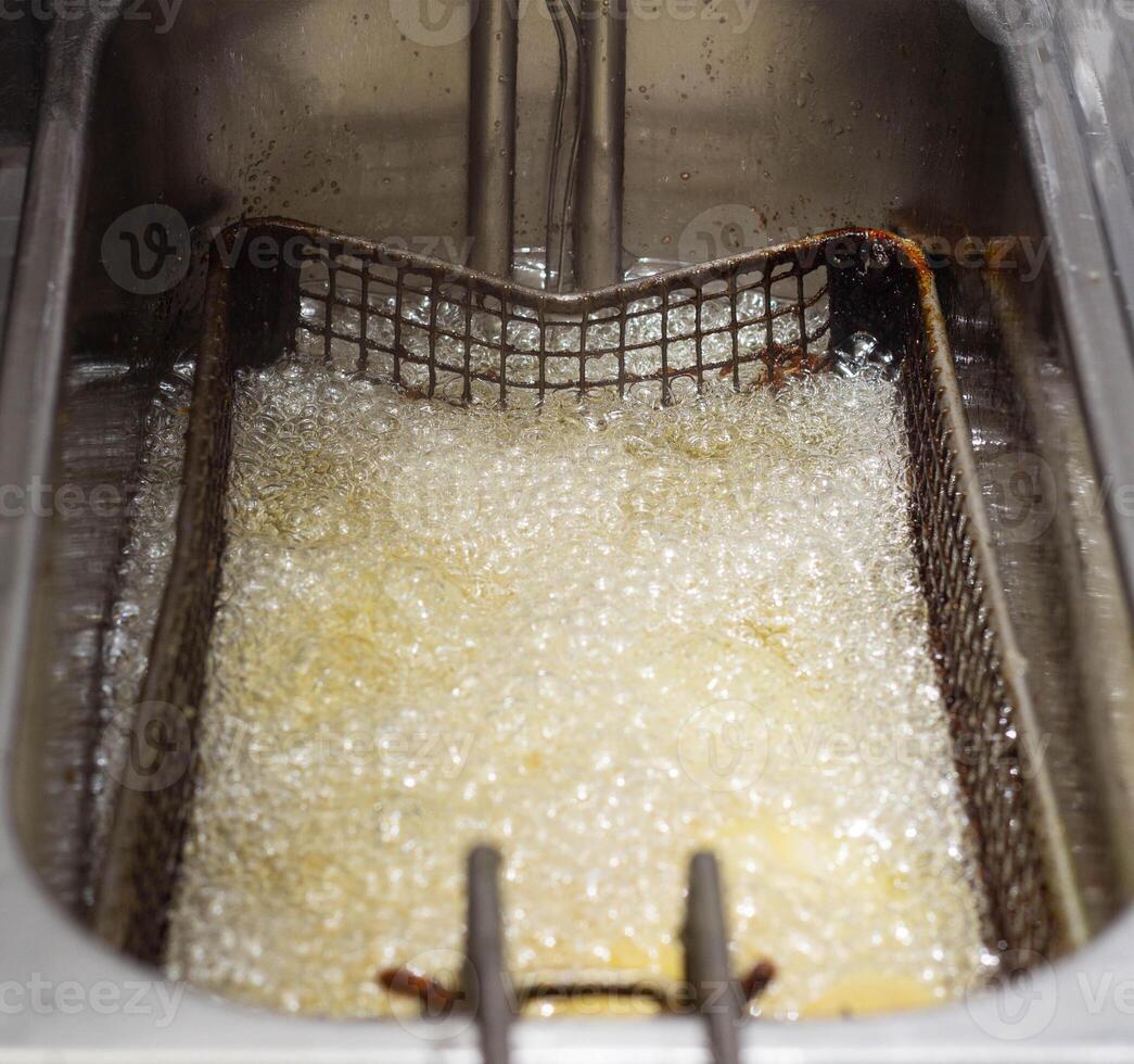 Boiling and boiling oil in which fries are fried and rustic in a fast food restaurant, background, cooked, boiling hot photo
