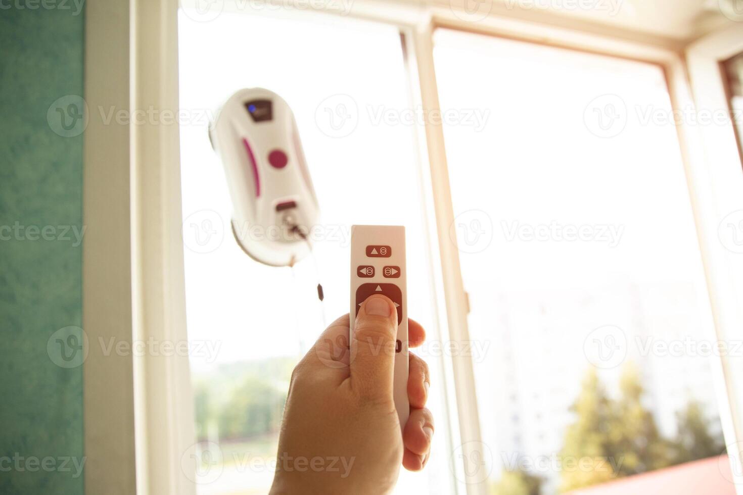 Remote control of a robotic window washer that washes glass from dirt and stains. Copy space for text photo