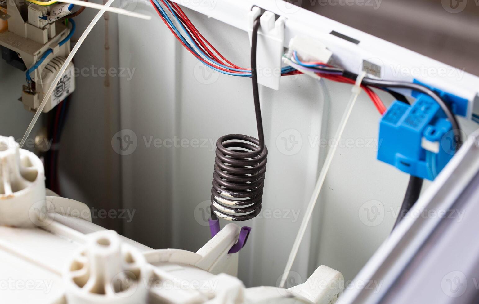 suspension spring of the washing machine tank to dampen vibration when spinning the washing machine. Breakdown and replacement of spare parts, copy space for text photo