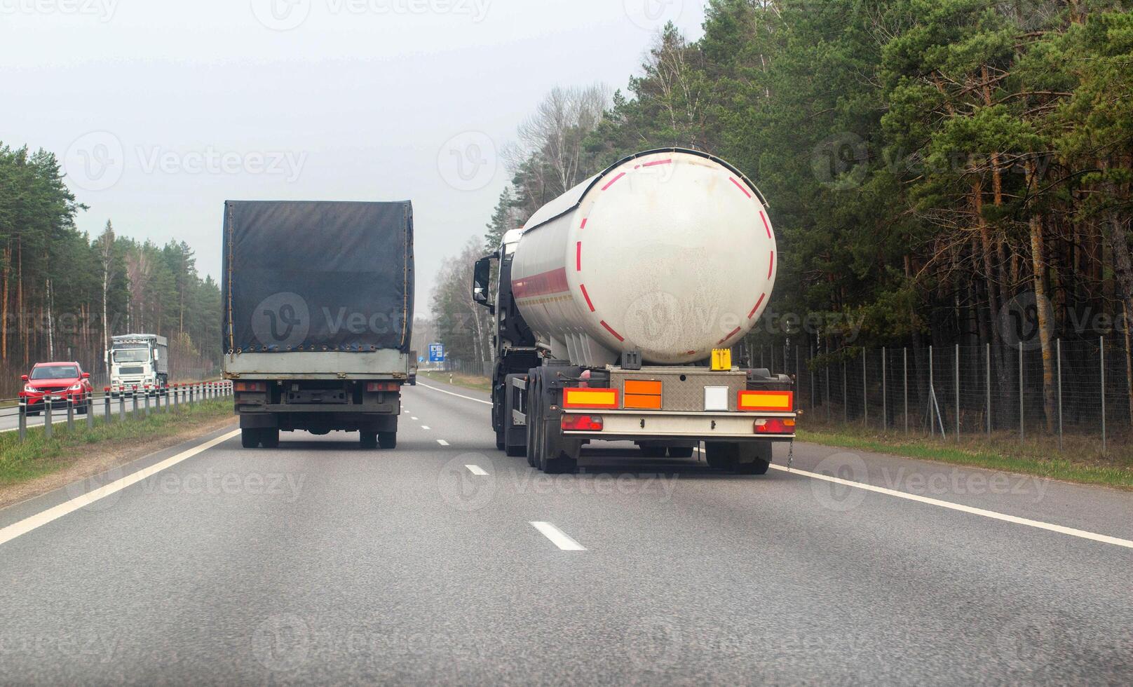A truck with a semi-trailer tanker transports dangerous cargo along the highway - liquefied gas. Logistics of dangerous goods. Copy space for text photo
