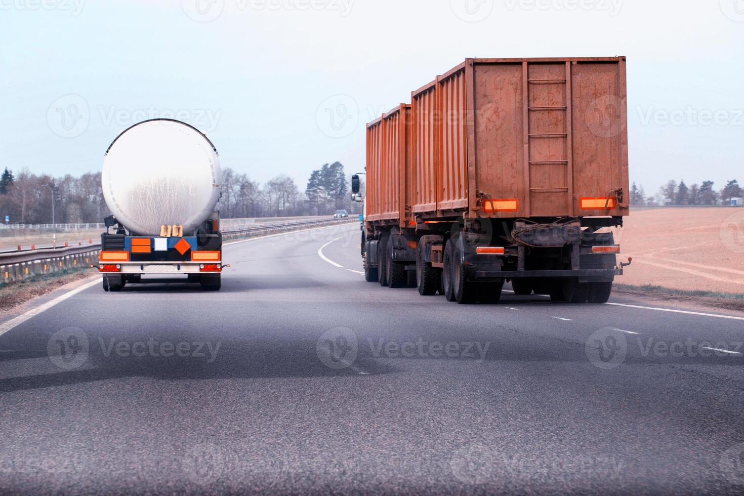 A truck with a semi-trailer tanker transports dangerous cargo along the highway - liquefied gas. Logistics of dangerous goods. Copy space for text photo