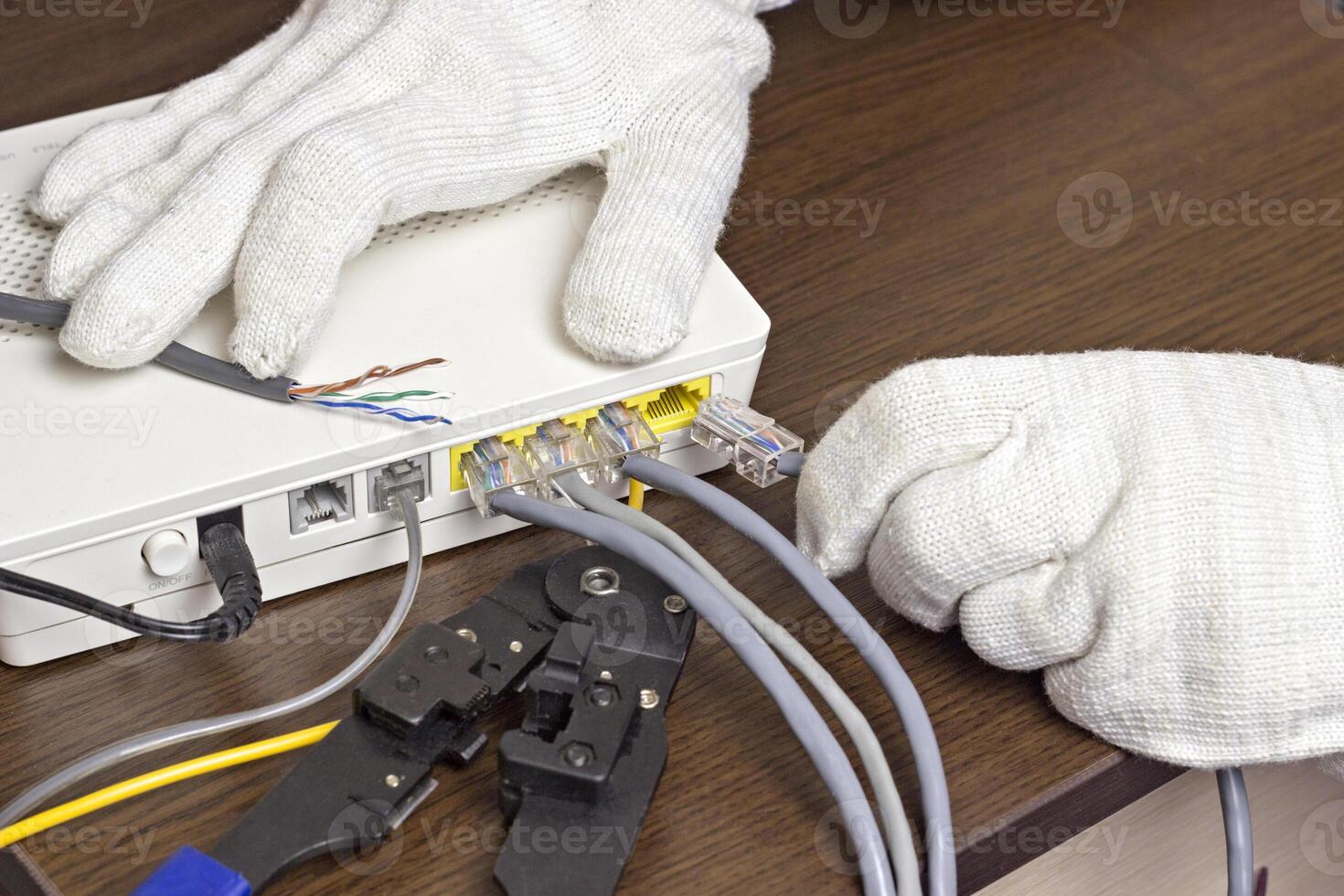A man connects a network cable to the modem, a close-up photo