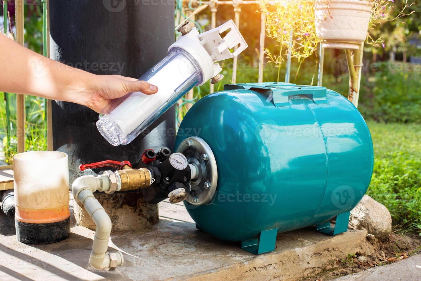 Water supply system from a well in a country house. New water filter. Hydraulic accumulator for storing water volume. Replacing a new water filter. photo