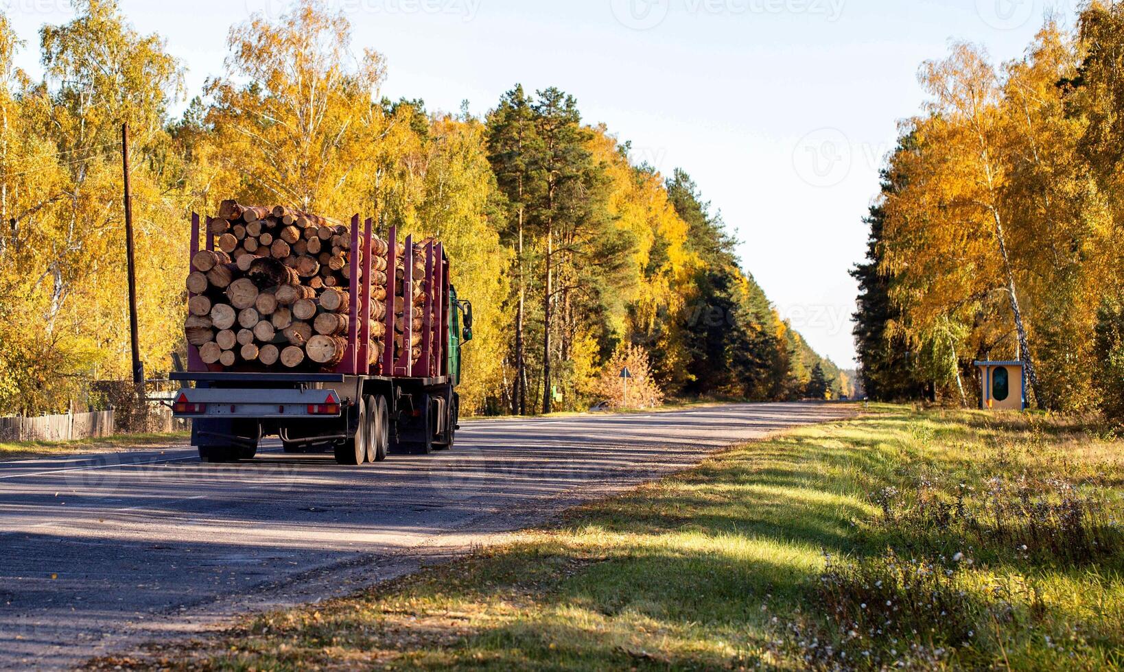 Transportation in trucks with special semi-trailers of forest logs. Transportation of timber and firewood on country roads, industry. photo