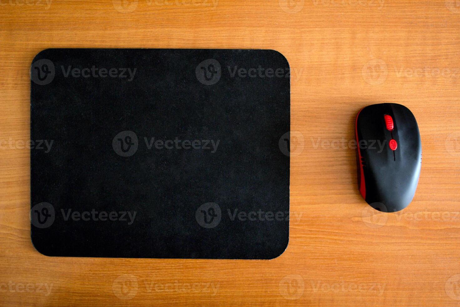 Computer mat and computer mouse on a wooden background, close-up, modern photo