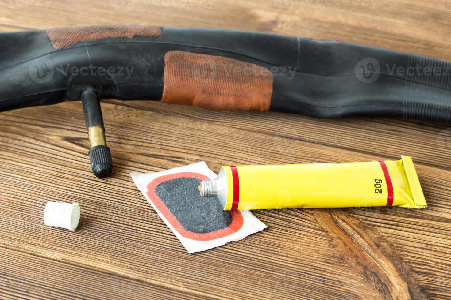 A set for sealing holes in chambers on a wooden background, a bicycle camera, repair photo