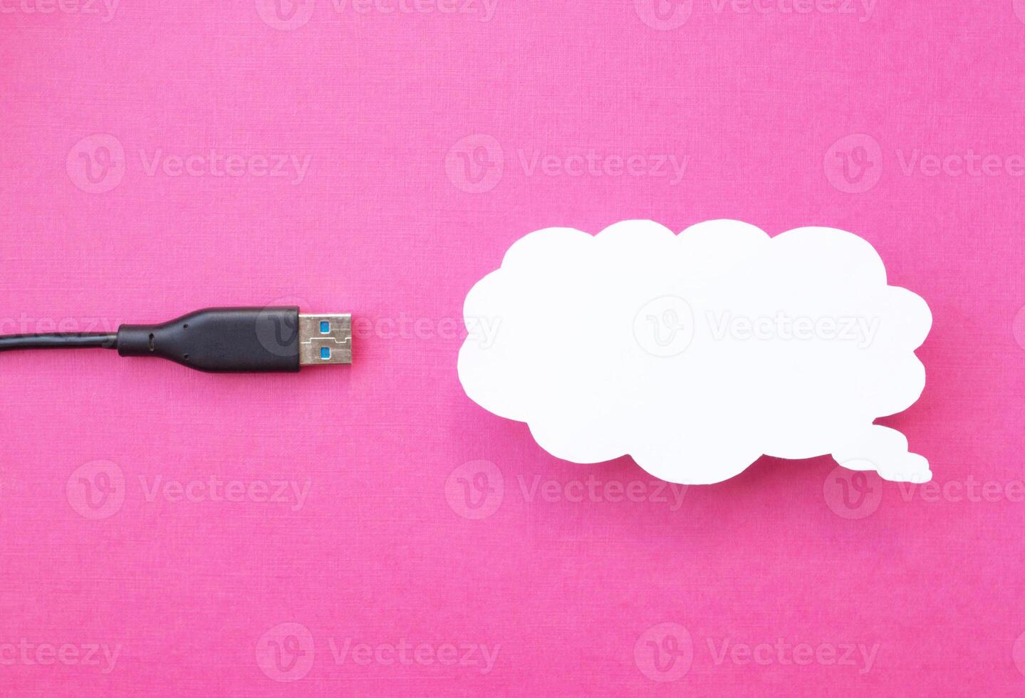 Cloud for data storage cut from paper on a pink background and cable usb, close-up, data storage on the Internet photo