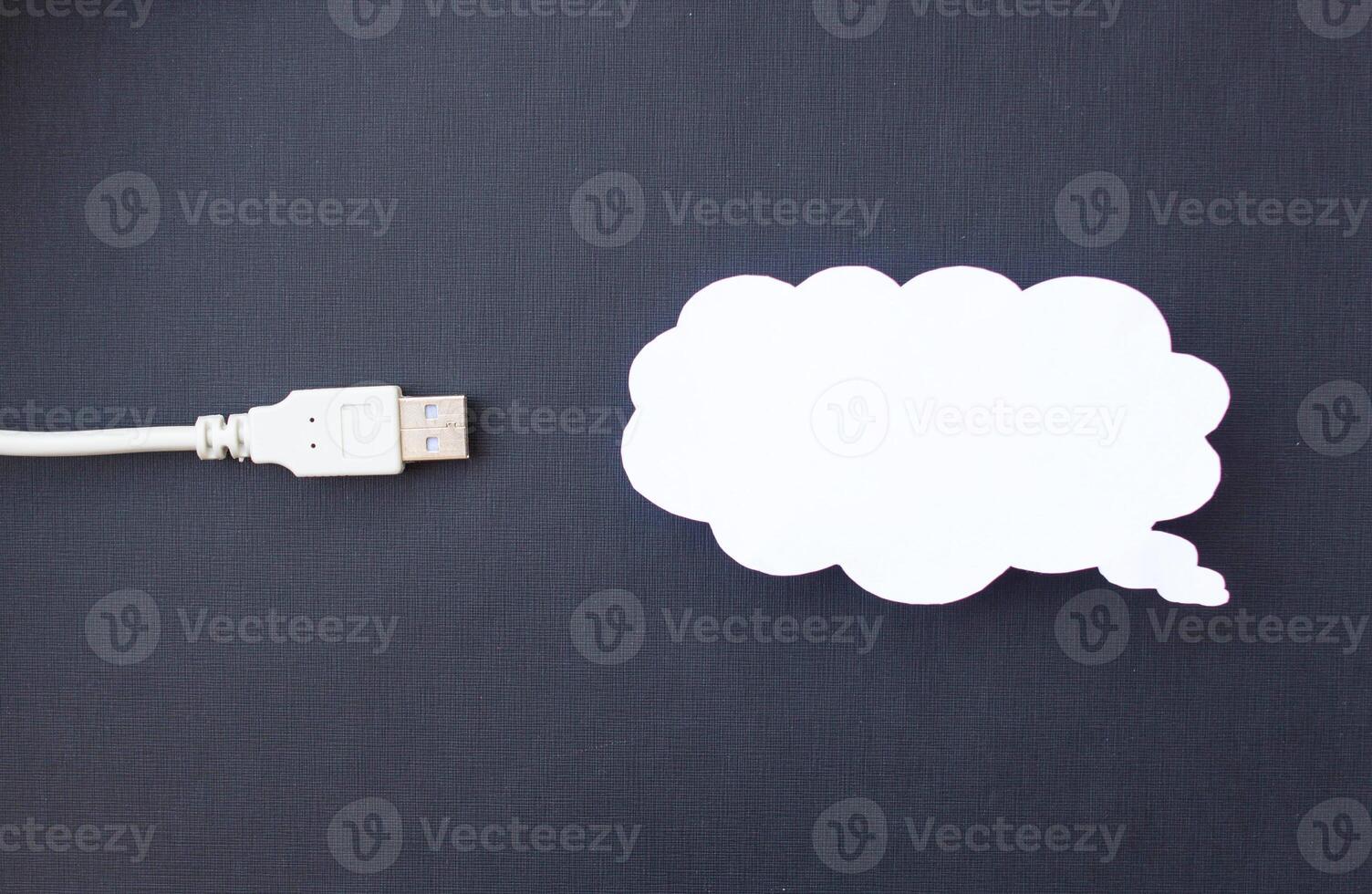 Cloud for data storage cut from paper on a black background and cable usb, close-up, data storage on the Internet photo