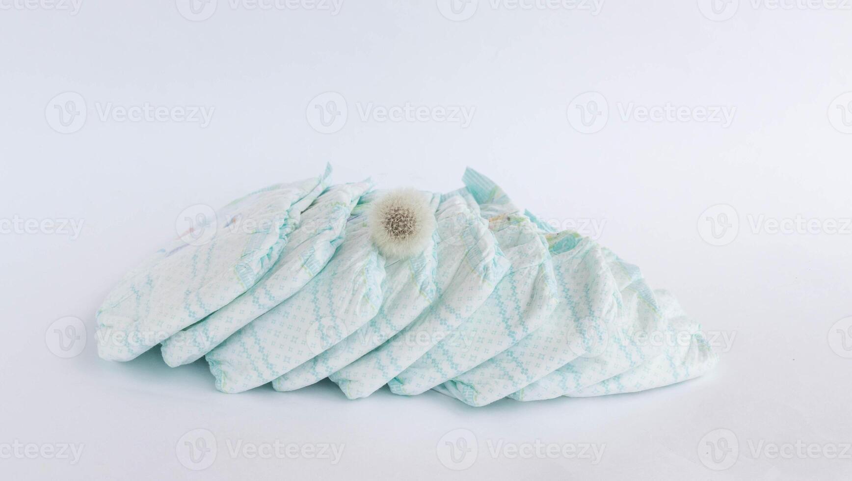 Baby diapers on a white background and a flower dandelion photo