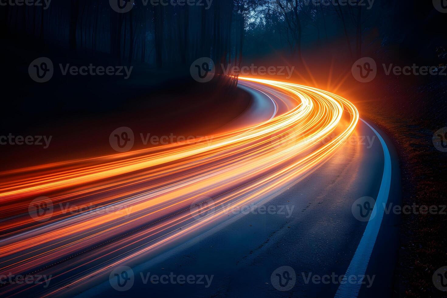 Long Exposure of Car Light Trails on a Curving Forest Road at Night photo
