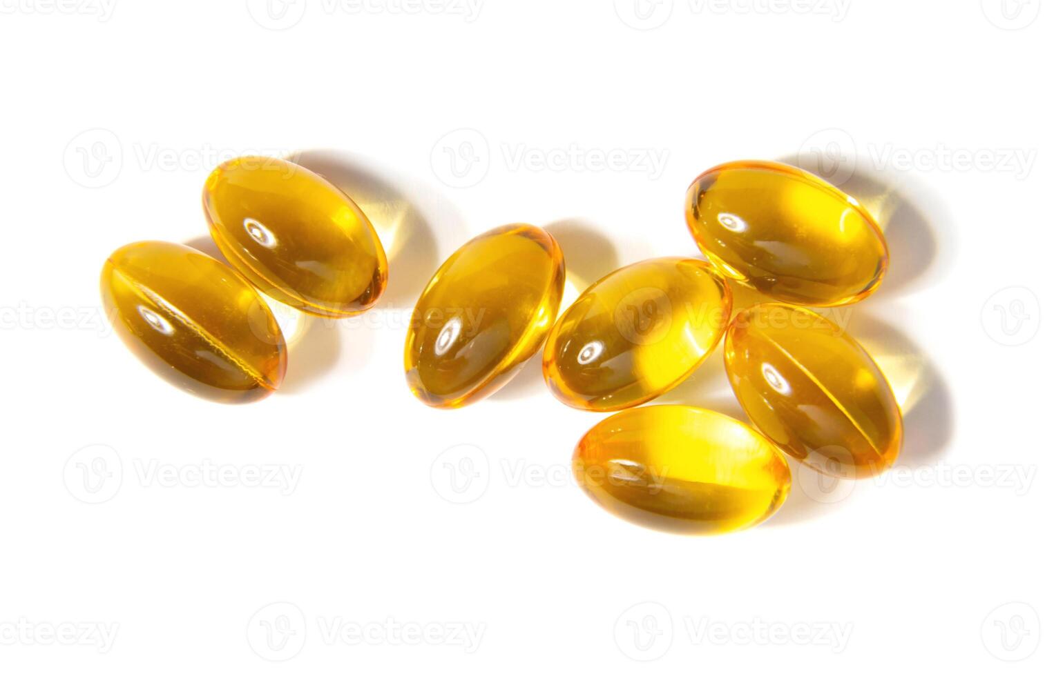 Golden Gelatin Capsules Arranged on a Clean White Surface Showcasing Their Smooth Texture photo
