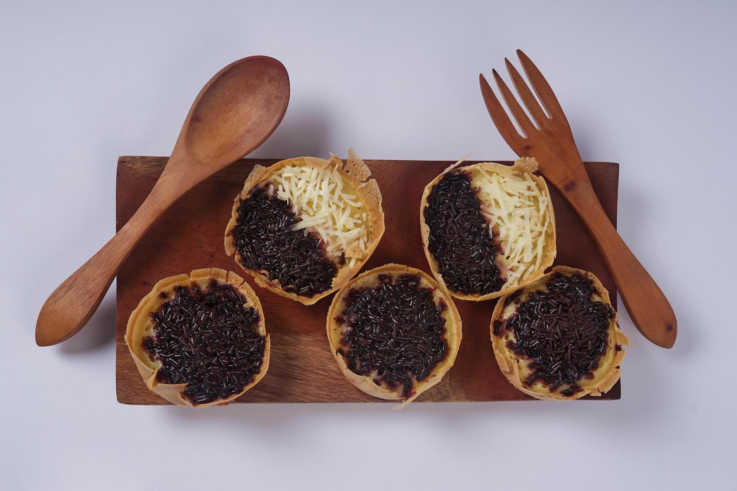 Martabak mini or terang bulan mini is Indonesian popular street food, made from flour, egg, yeast, topped with cheese or chocolate. Mini sweet martabak isolated on white background. photo