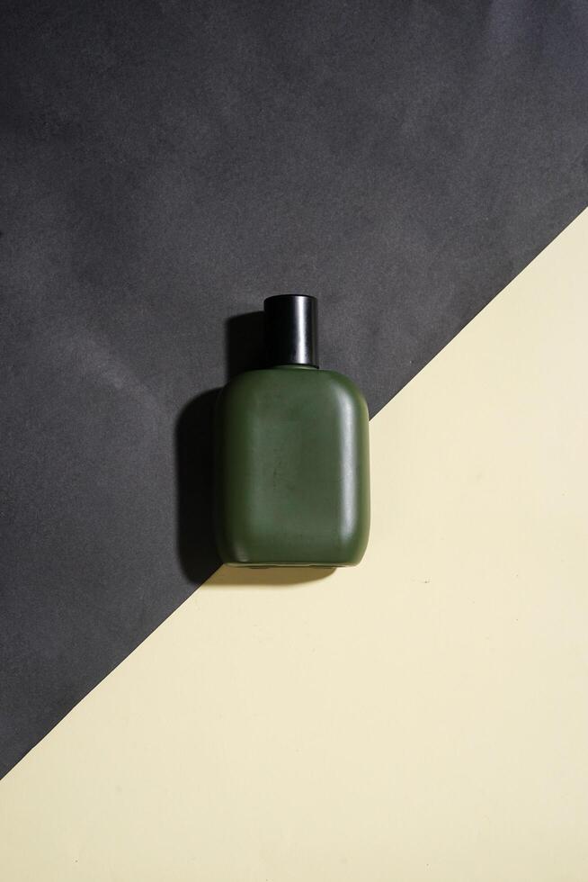 Perfume bottle with black spray on yellow and black background. High resolution photo. photo